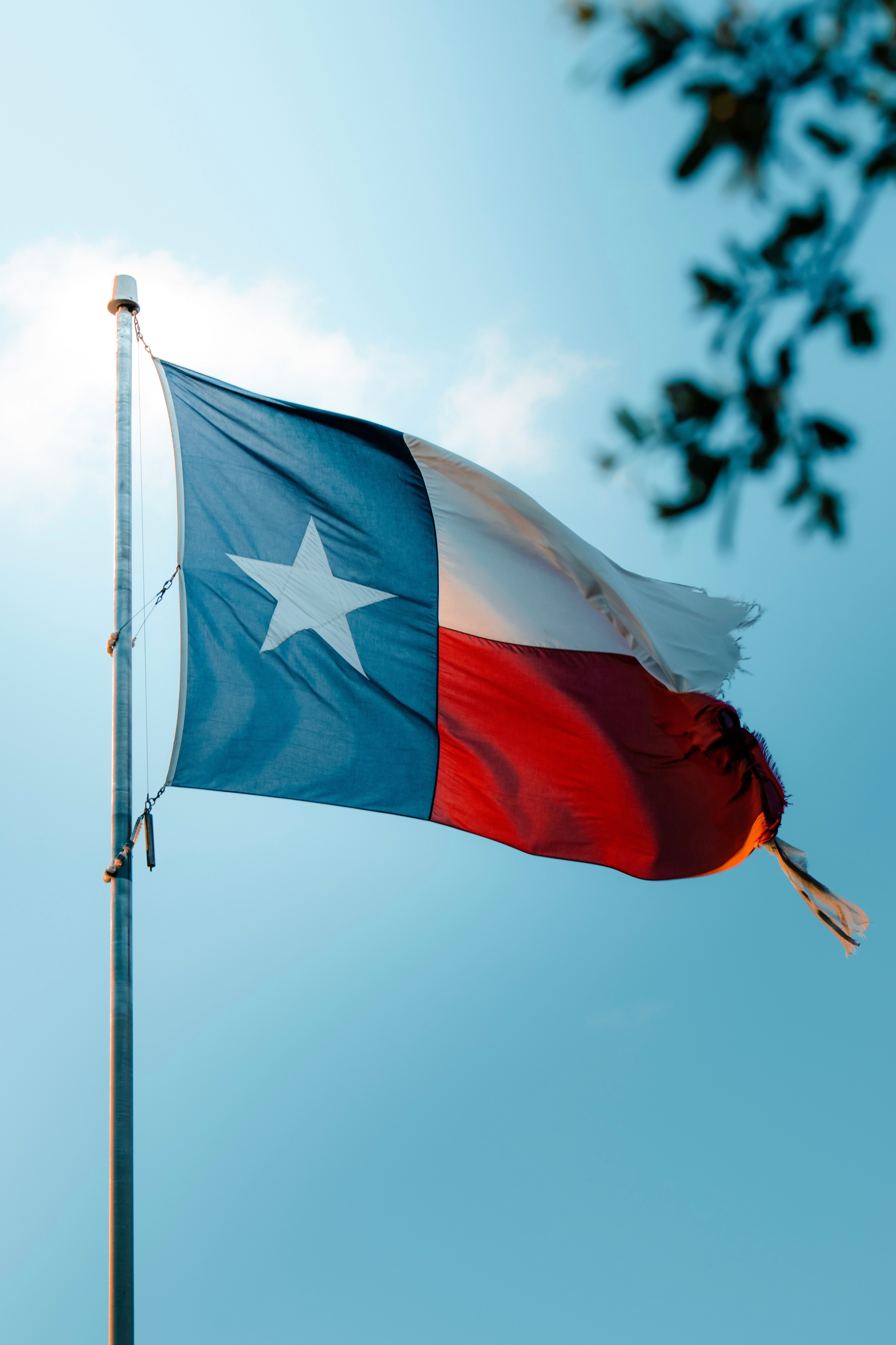 Texas flag waving in blue sky